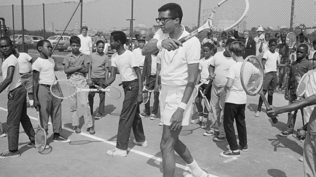 Arthur Ashe con un grupo de jóvenes en una pista de tenis